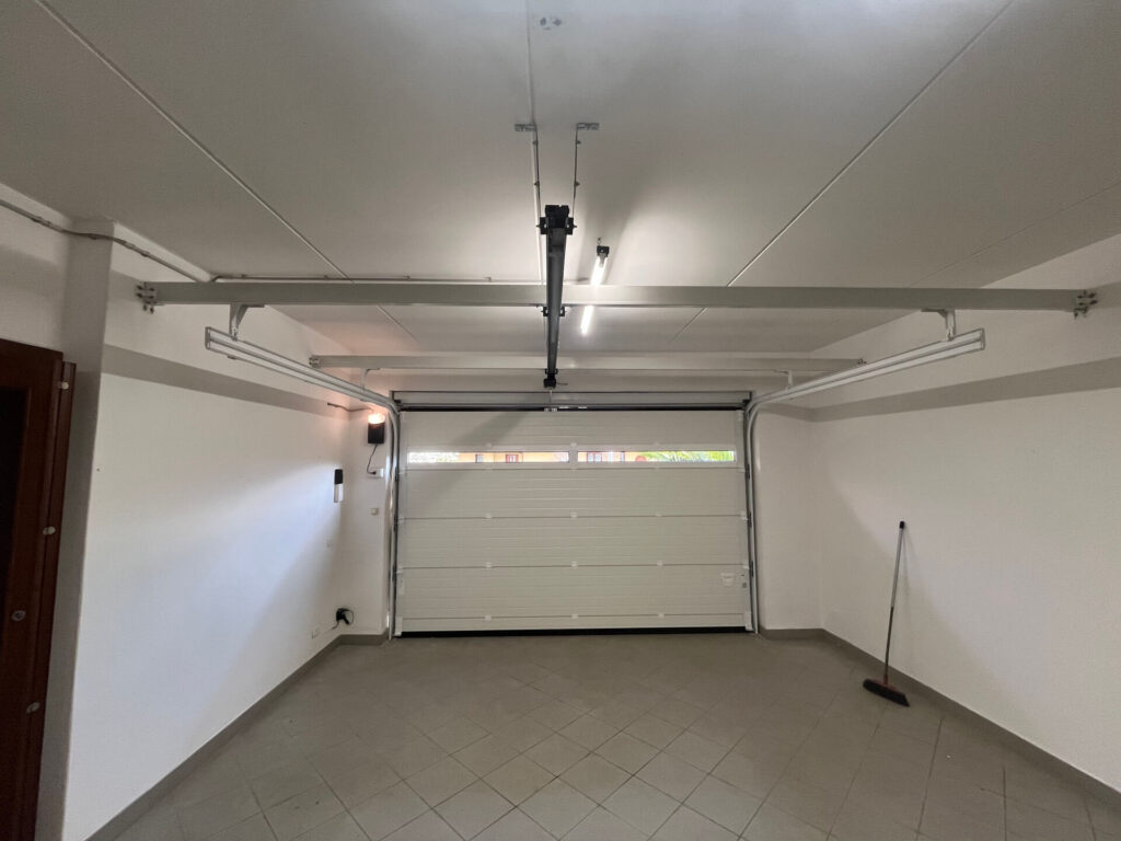 vista interna di portone garage sezionale con meccanismo di chiusura automatizzata - BBG