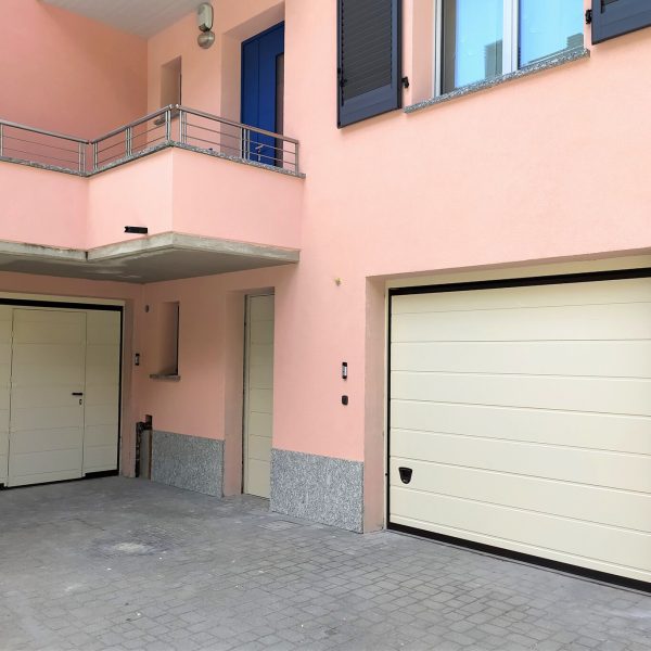Porta sezionale Urbino RAL 1013, motorizzata con porta pedonale laterale