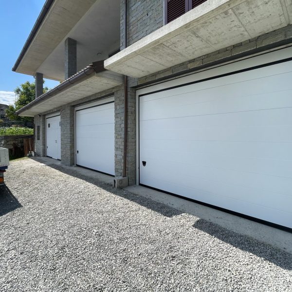 Porta sezionale modello Venezia bianco RAL 9010, con porta pedonale e oblò