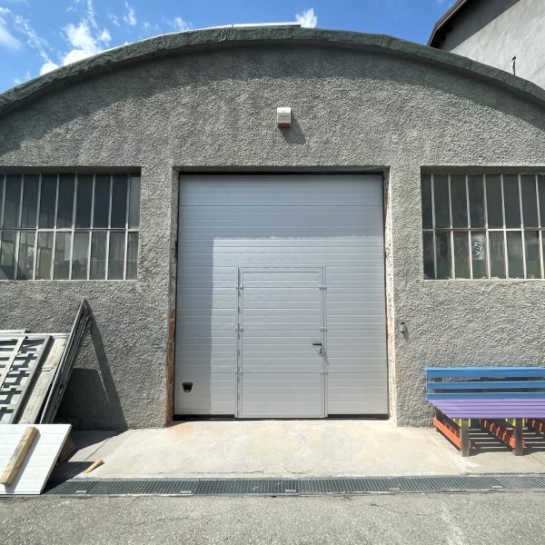 Porta sezionale industriale, con porta pedonale inserita, motorizzata