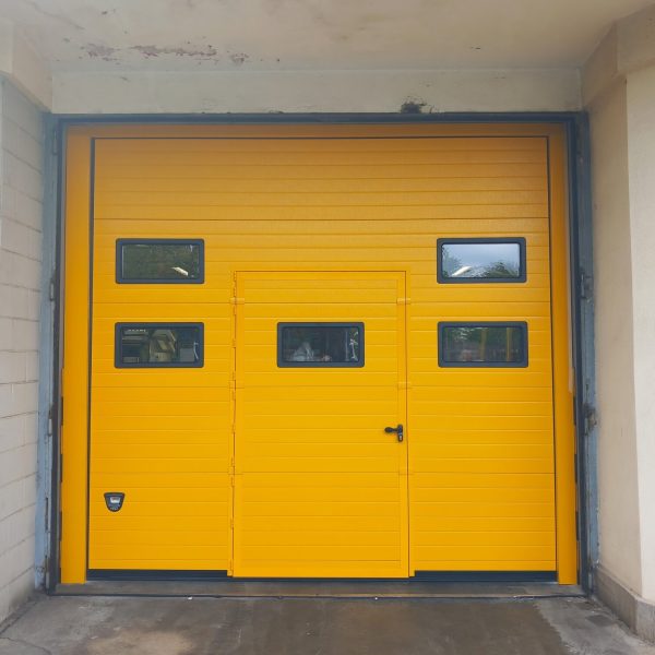 Porta sezionale industriale, con oblò e porta pedonale inserita