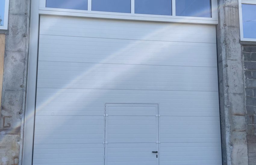 Porta sezionale industriale, con pedonale e sezioni finestrate