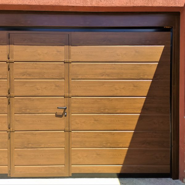 Porta sezionale residenziale effetto legno ciliegio modello Urbino con porta pedonale inserita