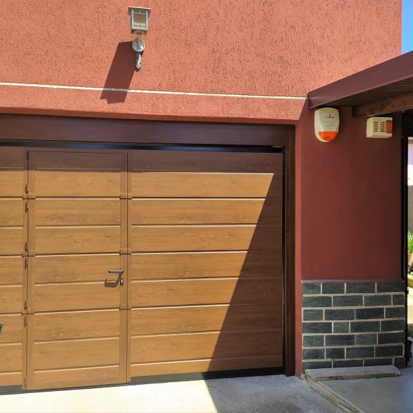 Porta sezionale residenziale effetto legno ciliegio modello Urbino con porta pedonale inserita