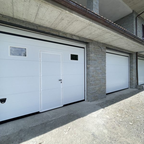Porta sezionale modello Venezia bianco RAL 9010, con porta pedonale e oblò
