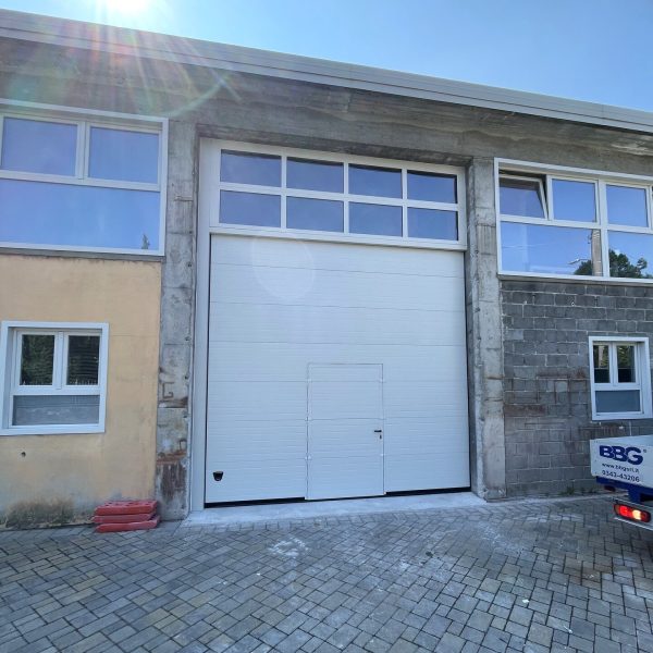 Porta sezionale industriale, con pedonale e sezioni finestrate