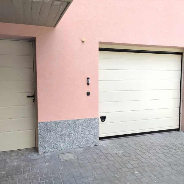 Porta sezionale Urbino RAL 1013, motorizzata con porta pedonale laterale