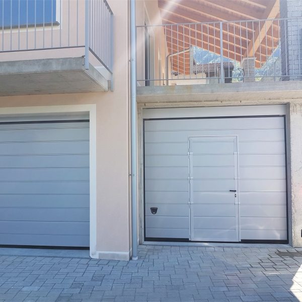 Porta sezionale residenziale modello Urbino due doghe liscio colore grigio RAL 9006 con porta pedonale inserita