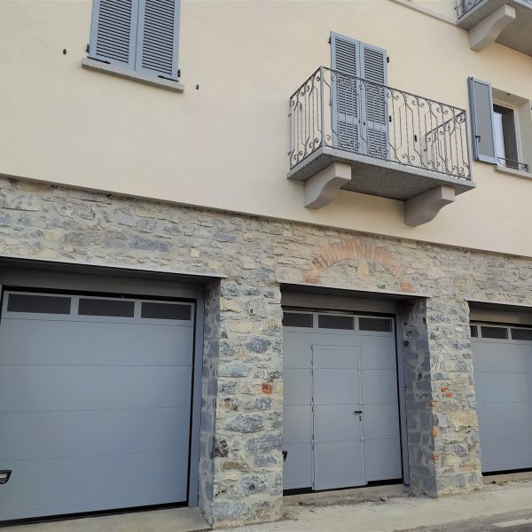 Porta sezionale Modena monodoga liscio grigio RAL 9006 con Tevere e porta pedonale inserita.